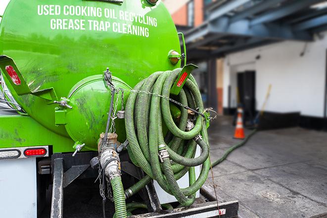 a professional technician pumping a restaurant's grease trap in Calimesa, CA