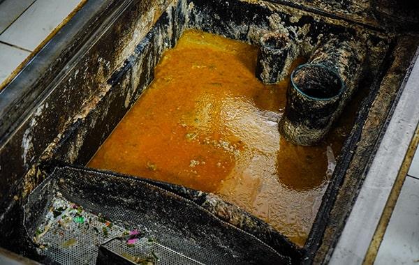 throughout grease trap cleaning, the trap is emptied, scraped, and cleaned to remove built-up grease and solids